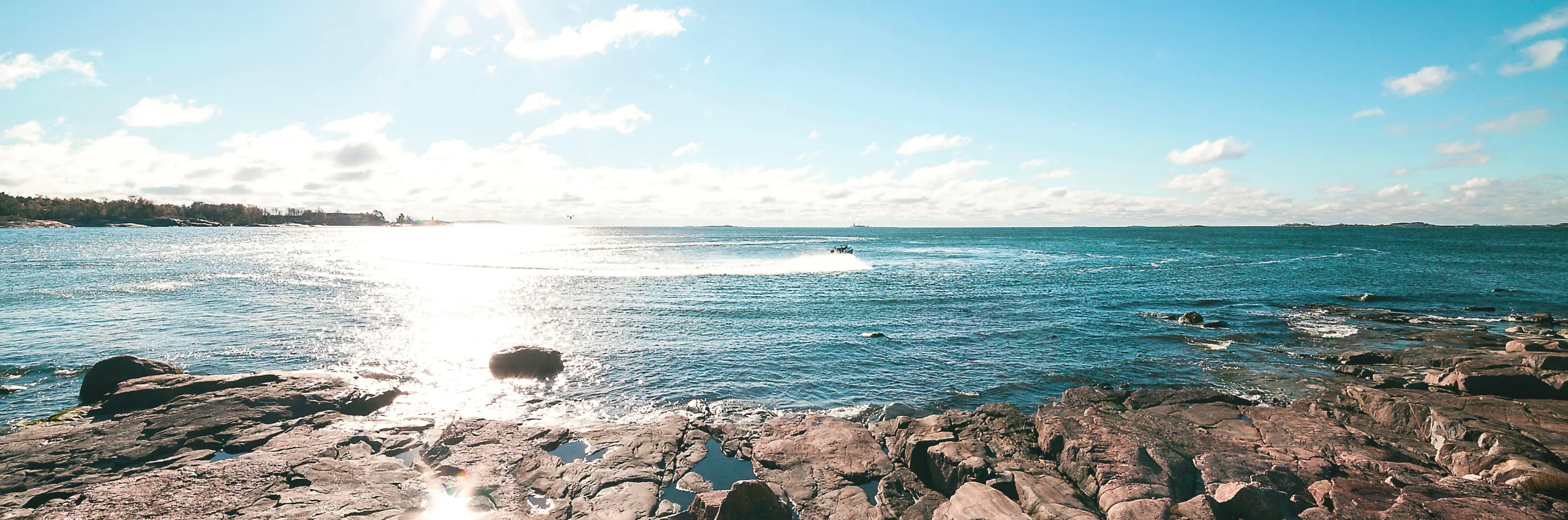 A rocky beach, sunny blue sky.