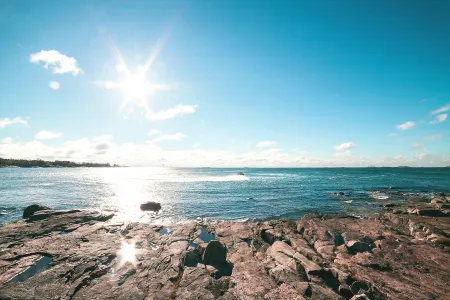 A rocky beach, sunny blue sky.